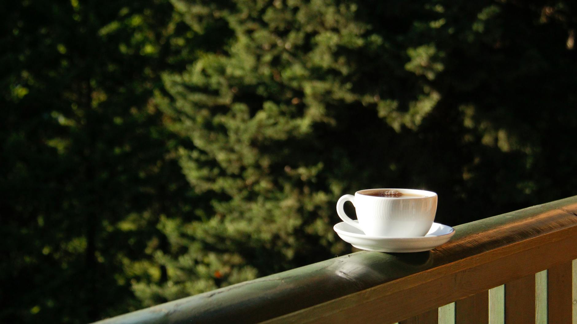 Filiżanka espresso na drewnianym blacie, poranne światło, kofeina a sen